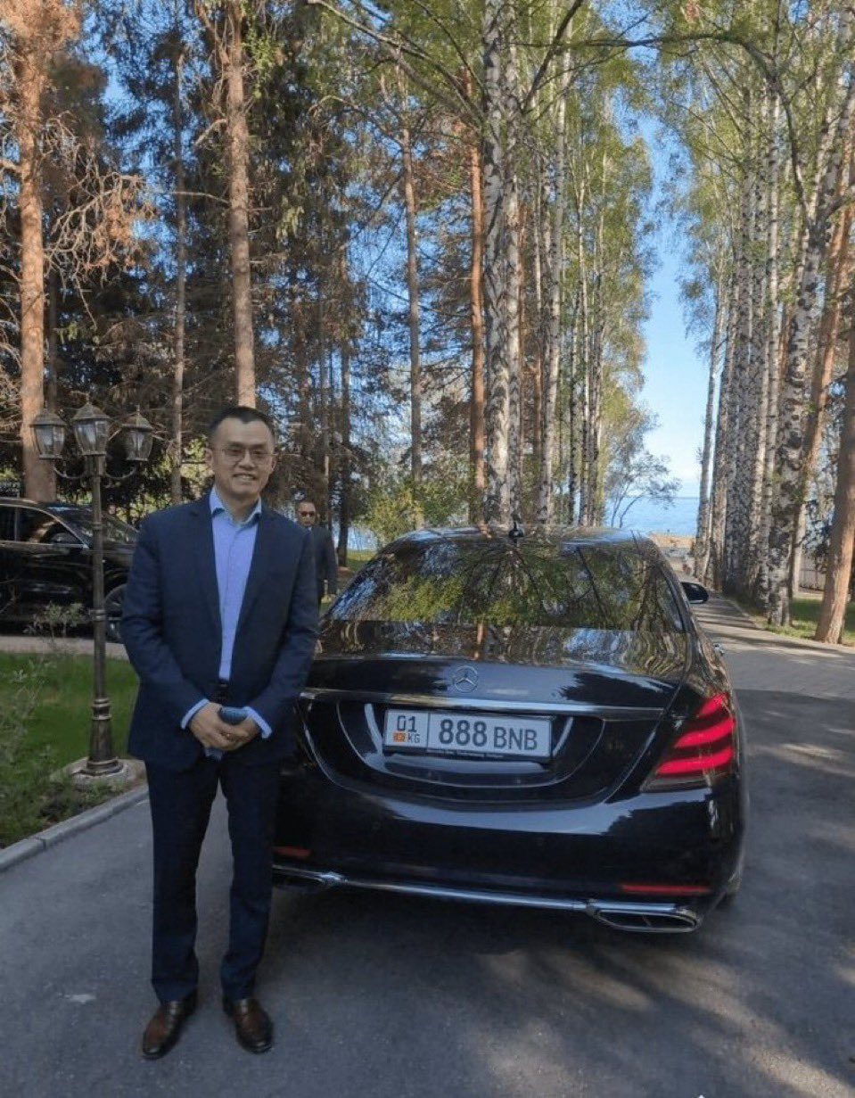 CZ standing beside a black sedan with a licence plate reading 888 BNB